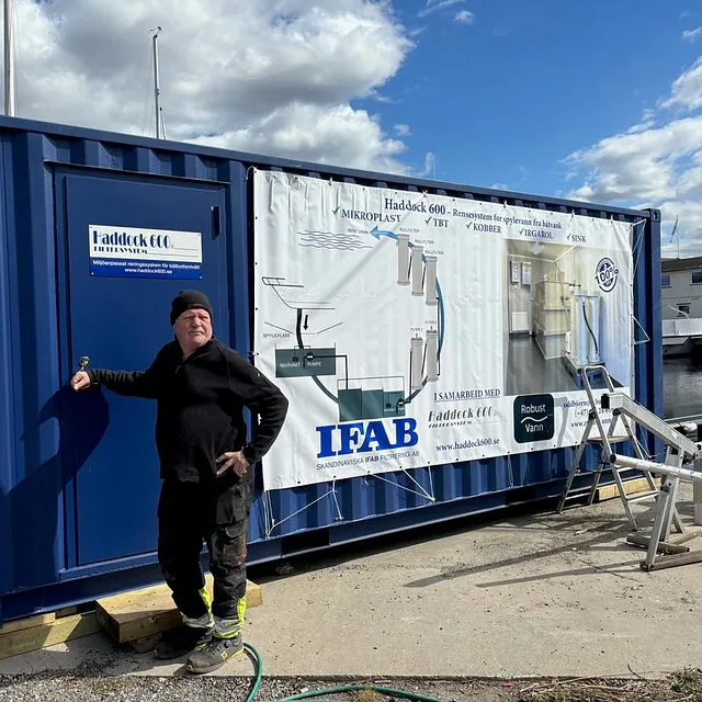 Mann ved blå container